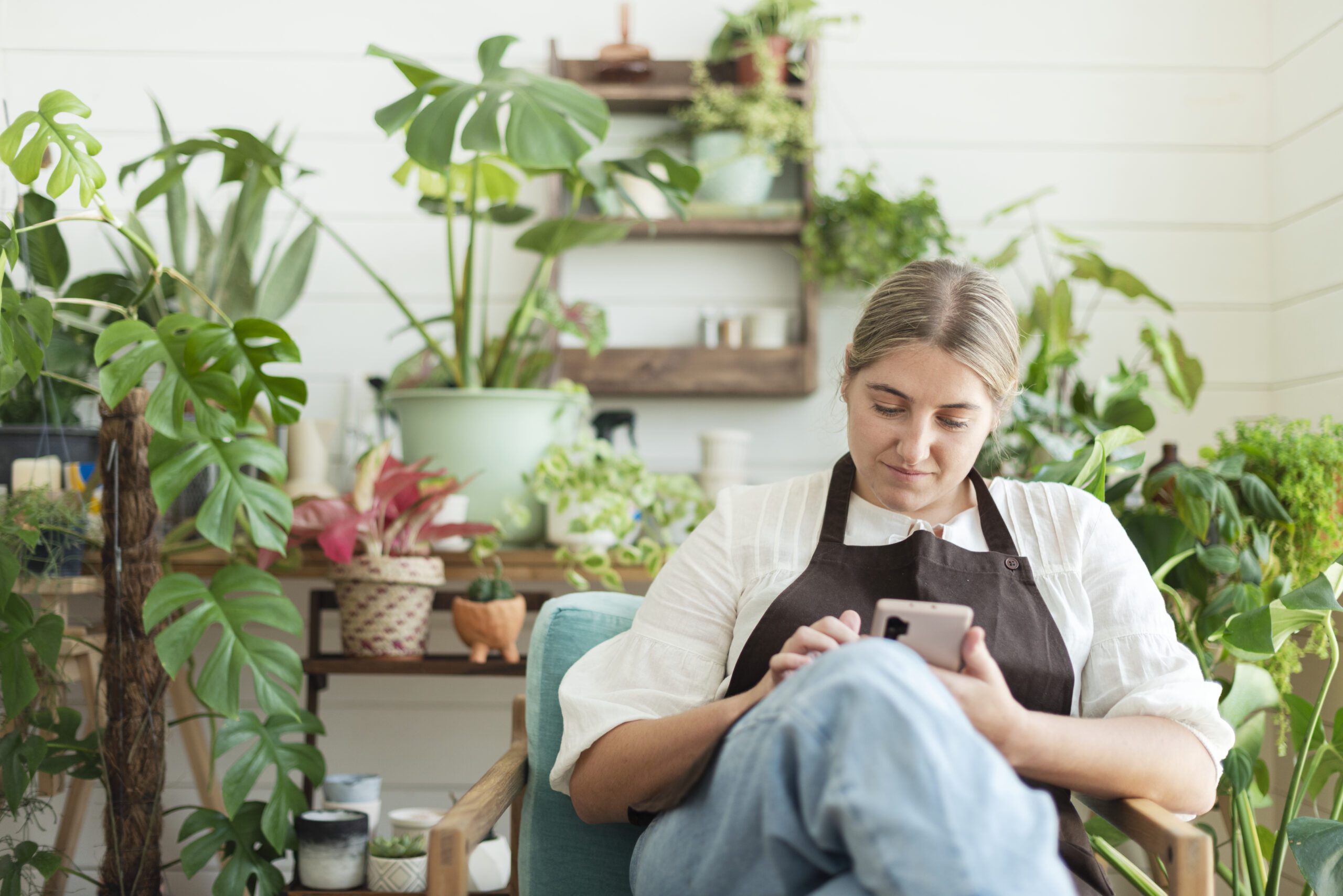 Florist och egenföretagare ser över sin bokföring i sin telefon
